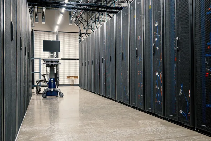 Rows of server racks along a bright data centre aisle