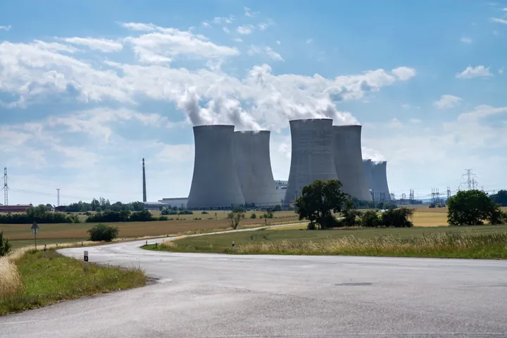Power plant cooling towers releasing steam under a blue sky