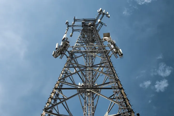 Telecommunications tower with antennas against a blue sky