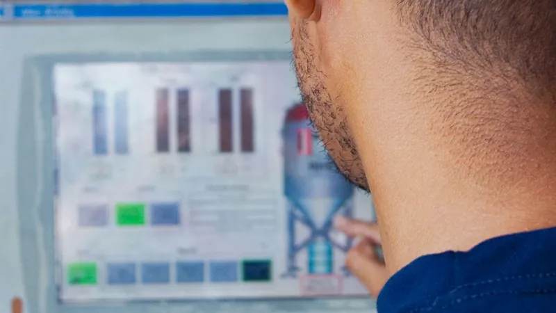 Engineer working at an industrial control panel touchscreen